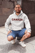 Say hello to the Oh-Canada Hoodie, featuring "Canada" in bold red and black plaid lettering that screams “I’m Canadian, and yes, I’m cozy!”