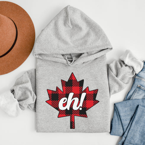 Featuring a bold Canadian maple leaf in classic red and black plaid with a proudly placed "Eh!" on the front, this hoodie is as Canadian as maple syrup on poutine.