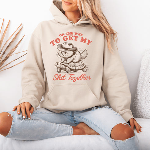 Featuring a determined cat hitching a ride on a turtle, this hoodie perfectly captures the vibe of “I’ll get there... eventually.”
