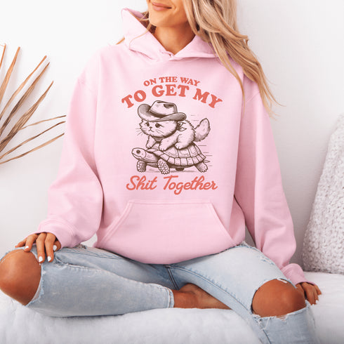 Featuring a determined cat hitching a ride on a turtle, this hoodie perfectly captures the vibe of “I’ll get there... eventually.”