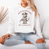 This hoodie is purr-fect for anyone who loves cats, chaos, and a healthy dose of cowboy attitude. Featuring a grumpy cat in a cowboy hat, pointing a tiny pistol