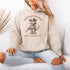 This hoodie is purr-fect for anyone who loves cats, chaos, and a healthy dose of cowboy attitude. Featuring a grumpy cat in a cowboy hat, pointing a tiny pistol