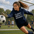 Female Soccer goalie wearing a “Classy Until Kickoff” hoodie standing on a soccer field during a youth soccer game