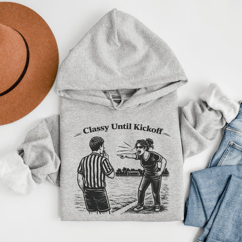 Funny soccer hoodie with “Classy Until Kickoff” text and illustration of woman yelling at referee on soccer field