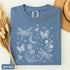 Comfort Colors garment-dyed t-shirt featuring a vintage botanical design with dragonflies, butterflies, bees, wildflowers, dandelions, floating seeds, hearts, stars, and a crescent moon.