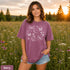 Comfort Colors garment-dyed t-shirt featuring a vintage botanical design with dragonflies, butterflies, bees, wildflowers, dandelions, floating seeds, hearts, stars, and a crescent moon.