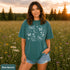 Comfort Colors garment-dyed t-shirt featuring a vintage botanical design with dragonflies, butterflies, bees, wildflowers, dandelions, floating seeds, hearts, stars, and a crescent moon.