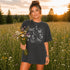 Comfort Colors garment-dyed t-shirt featuring a vintage botanical design with dragonflies, butterflies, bees, wildflowers, dandelions, floating seeds, hearts, stars, and a crescent moon.