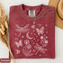 Comfort Colors garment-dyed t-shirt featuring a vintage botanical design with dragonflies, butterflies, bees, wildflowers, dandelions, floating seeds, hearts, stars, and a crescent moon.