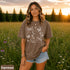 Comfort Colors garment-dyed t-shirt featuring a vintage botanical design with dragonflies, butterflies, bees, wildflowers, dandelions, floating seeds, hearts, stars, and a crescent moon.