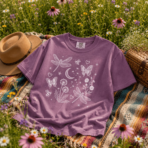 Comfort Colors garment-dyed t-shirt featuring a vintage botanical design with dragonflies, butterflies, bees, wildflowers, dandelions, floating seeds, hearts, stars, and a crescent moon.