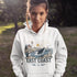 Person wearing a white hoodie with a coastal design and 'East Coast' text outdoors.