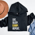 Introducing the ultimate camper's companion: the "Eat. Sleep. Camp. Repeat." Hoodie! This isn't just any ordinary piece of clothing. It's your best friend in the wilderness, your cozy confidante under the stars, and quite possibly the most honest representation of your weekend plans.
