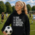 Teen wearing “Eat Sleep Soccer Repeat” hoodie holding a soccer ball on a soccer field during a game, casual soccer apparel