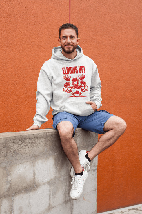 Get ready to hit the ice (or the couch) in style with our "Elbows Up!" hoodie! Featuring a tough-as-nails moose rocking a Canada hockey shirt and helmet while flexing its muscles