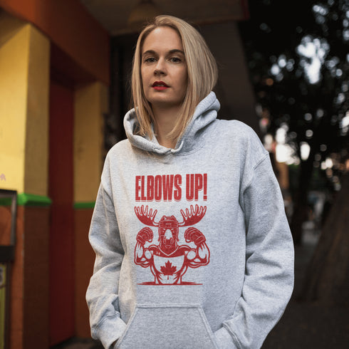 Get ready to hit the ice (or the couch) in style with our "Elbows Up!" hoodie! Featuring a tough-as-nails moose rocking a Canada hockey shirt and helmet while flexing its muscles