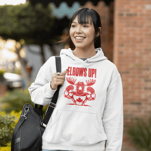 Get ready to hit the ice (or the couch) in style with our "Elbows Up!" hoodie! Featuring a tough-as-nails moose rocking a Canada hockey shirt and helmet while flexing its muscles