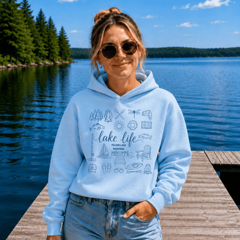 Customizable Lake Life hoodie featuring lake-themed illustrations including a dock, canoe, sailboat, campfire, fishing gear, and personalized lake name design on a unisex Gildan 18500 hoodie available in multiple colors.