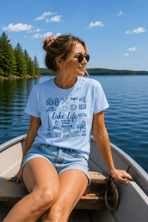 Woman sitting in a boat on a lake wearing a 'lake life' t-shirt.