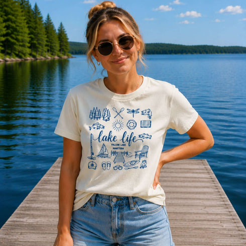 Woman wearing a 'lake life' t-shirt on a dock by a lake