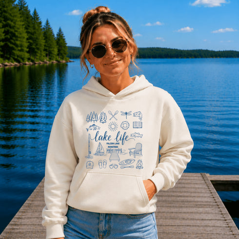 Customizable Lake Life hoodie featuring lake-themed illustrations including a dock, canoe, sailboat, campfire, fishing gear, and personalized lake name design on a unisex Gildan 18500 hoodie available in multiple colors.