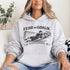 Woman wearing grey hoodie with “Fear The Goalie” soccer goalkeeper design featuring diving goalie making a save