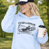 Woman wearing grey hoodie with “Fear The Goalie” soccer goalkeeper design featuring diving goalie making a save