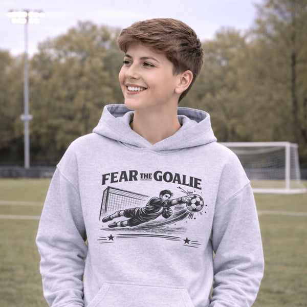 youth wearing grey hoodie with “Fear The Goalie” soccer goalkeeper design featuring diving goalie making a save