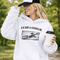 woman wearing grey hoodie with “Fear The Goalie” soccer goalkeeper design featuring diving goalie making a save