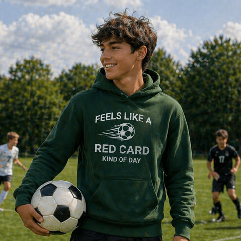 Person wearing a green hoodie with a soccer-themed quote on a soccer field