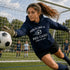 Soccer goalkeeper in action wearing a hoodie with text on a soccer field.