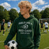 Person wearing a green hoodie with a soccer-themed message on a soccer field
