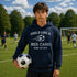Person wearing a hoodie with a soccer-themed message on a soccer field