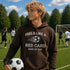 Person wearing a hoodie with a soccer-themed message on a soccer field