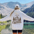Vintage outdoor graphic hoodie featuring a small left chest design and a large mountain landscape graphic on the back, available in multiple colors and shown in various lifestyle and product mockups.