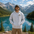 Vintage outdoor graphic hoodie featuring a small left chest design and a large mountain landscape graphic on the back, available in multiple colors and shown in various lifestyle and product mockups.