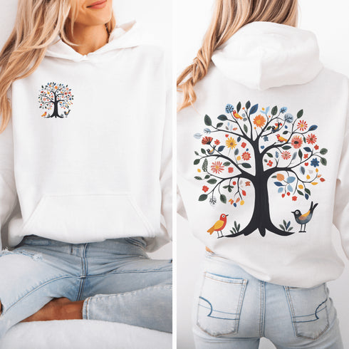 This hoodie features a delightful folk art design of vibrant birds perched in a tree adorned with colorful leaves and blooming flowers, creating a scene that radiates joy and creativity.