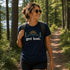 Woman hiking in a forest wearing a 'get lost' t-shirt.