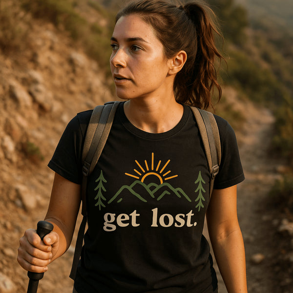 Woman hiking wearing a black get lost t-shirt with mountain and sun graphic