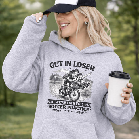 Funny soccer hoodie design showing two kids riding a bike to soccer practice with the phrase get in loser we’re late for soccer practice