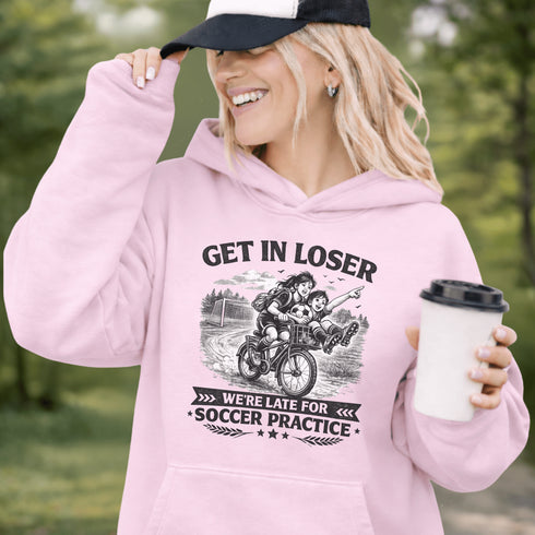 Funny soccer hoodie design showing two kids riding a bike to soccer practice with the phrase get in loser we’re late for soccer practice