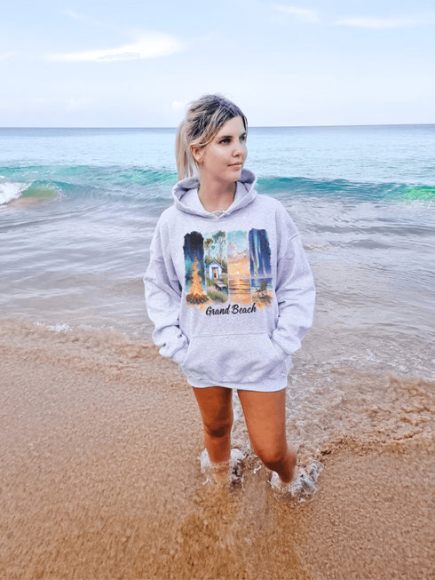 Celebrate the natural beauty and charm of Grand Beach with this cozy and stylish hoodie, featuring a soft watercolor collage of iconic local scenes.