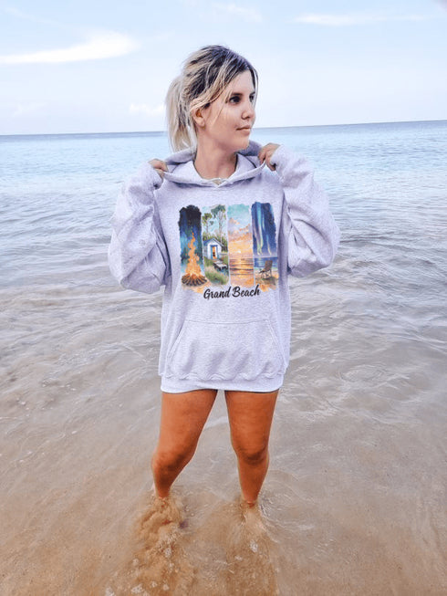 Celebrate the natural beauty and charm of Grand Beach with this cozy and stylish hoodie, featuring a soft watercolor collage of iconic local scenes.