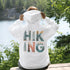 woman wearing hiking hoodie with large nature graphic on back sitting on log in forest