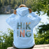 woman wearing hiking hoodie with large nature graphic on back sitting on log in forest