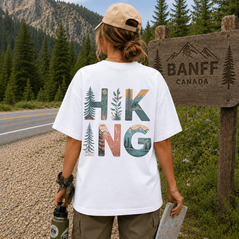 Person wearing a 'Hiking' t-shirt by a Banff, Canada sign.