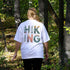 Person wearing a white t-shirt with 'Hiking' design in a forest