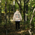woman wearing hiking hoodie with large nature graphic on back walking in the forest