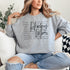 Hockey Mom sweatshirt with handwritten script typography and descriptive text design on a cozy crewneck, perfect for rink moms and hockey season