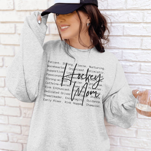 Hockey Mom sweatshirt with handwritten script typography and descriptive text design on a cozy crewneck, perfect for rink moms and hockey season